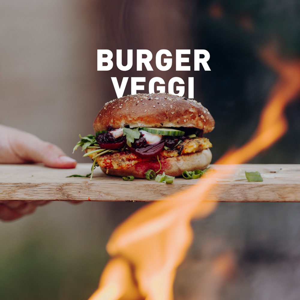 Une personne tenant un hamburger au-dessus d'un feu