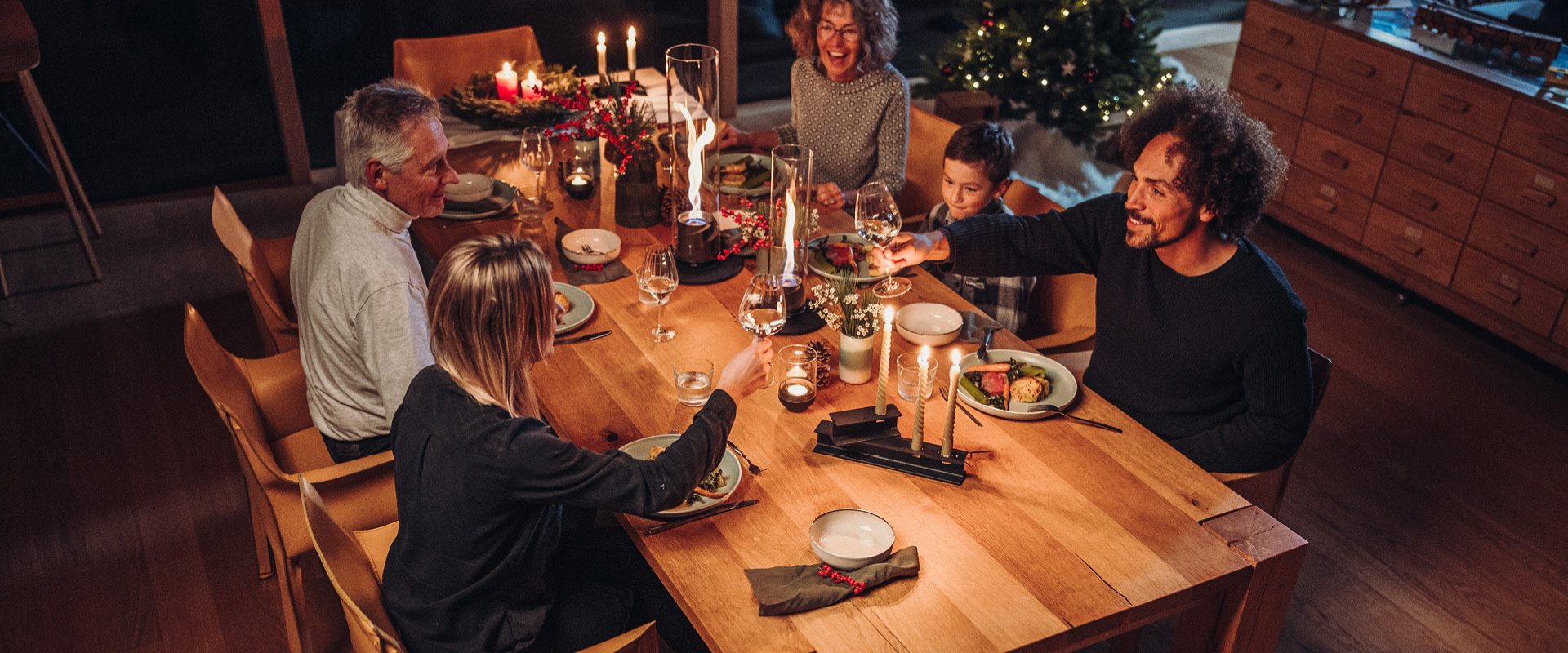 Ein Bild zeigt eine Gruppe von Menschen, die um einen Tisch sitzen, mit der BOWL Fire Bowl.