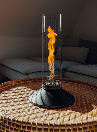 SPIN X Tischfeuer schwarz brennt und steht dabei auf einem Wohnzimmetisch