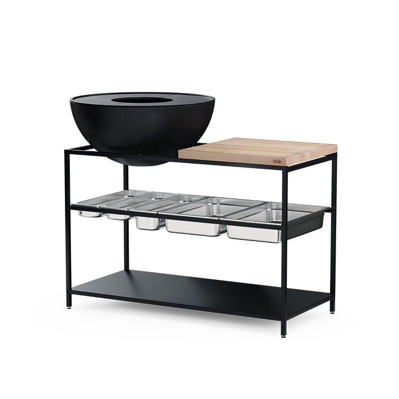 Un cadre en métal noir avec une Plancha à découper en bois et un BOWL dessus, avec le jeu de contenants en acier inoxydable 00764 FIRE KITCHEN (5 pièces) ajoutant une touche fonctionnelle et élégante à la scène.