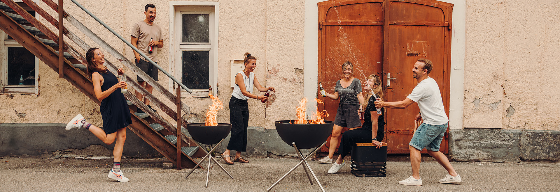 a group of people standing around a fire pit.