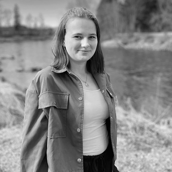 Une fille debout devant un lac