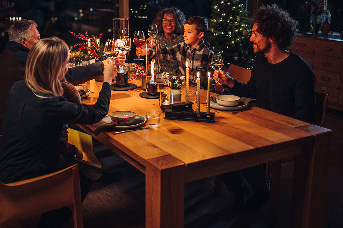 HENRY METAL I+II Kerzenhalter-Set schwarz Das Foto zeigt eine Gruppe von Personen, die um einen Tisch herum sitzen, mit dem HENRY METAL II Kerzenhalter in Schwarz.