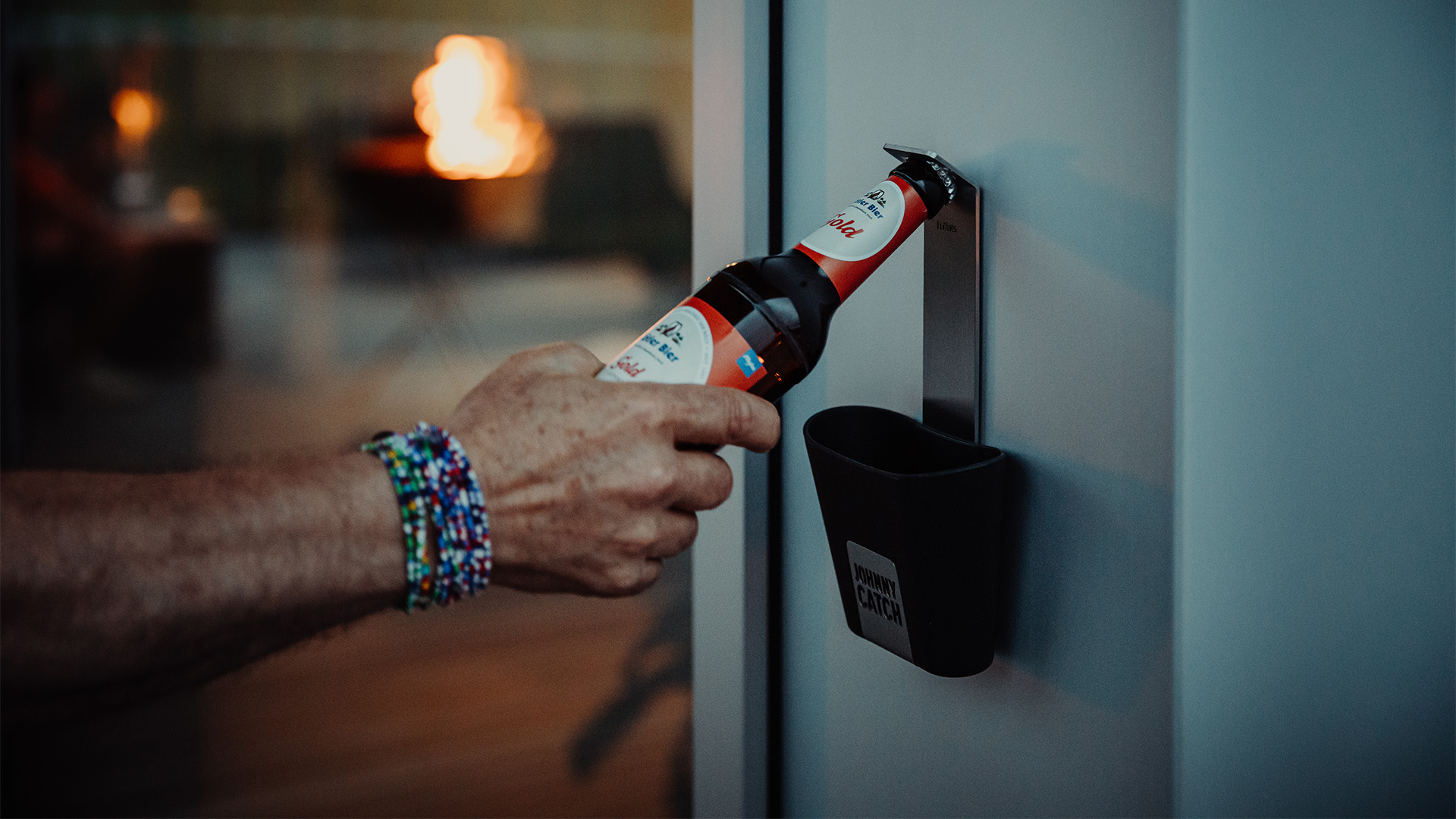 Scène montrant une personne en train d'ouvrir une bouteille avec un décapsuleur, où le Johnny Catch Cup se distingue par son élégance pratique.