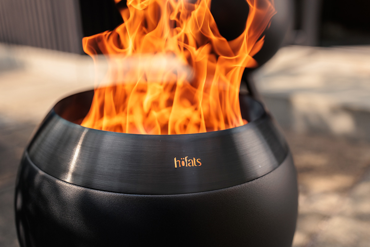 MOON 45 all black Fire Basket with low stand MOON ist mit fokussierter brennender Flamme abgebildet.