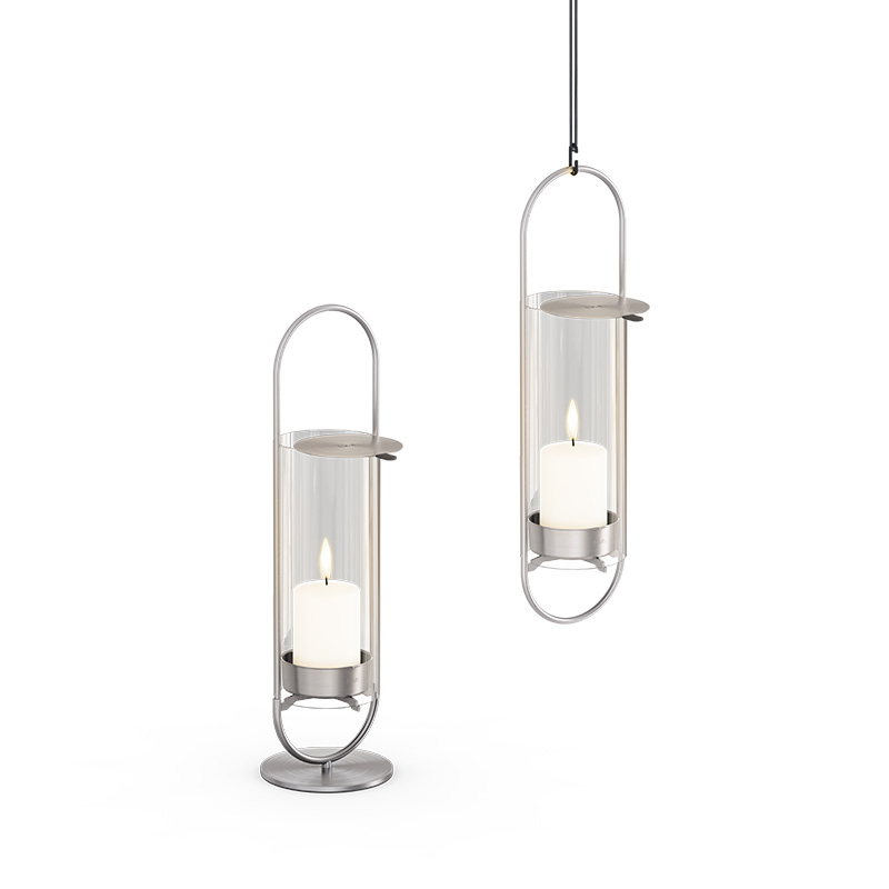 OVAL CANDLE 35 silber Abgebildet sind zwei silberne Metalllaternen mit weißem Glas, mit dem OVAL CANDLE 35 Glass Cylinder.