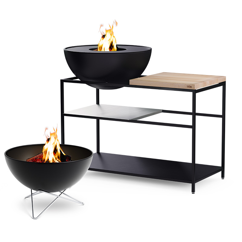 FIRE KITCHEN avec BOWL 70 Set Plancha Grille basse La photo présente un brasero et une table avec un feu, avec le FIRE KITCHEN avec BOWL 70 Plancha BBQ Set incl. roues.