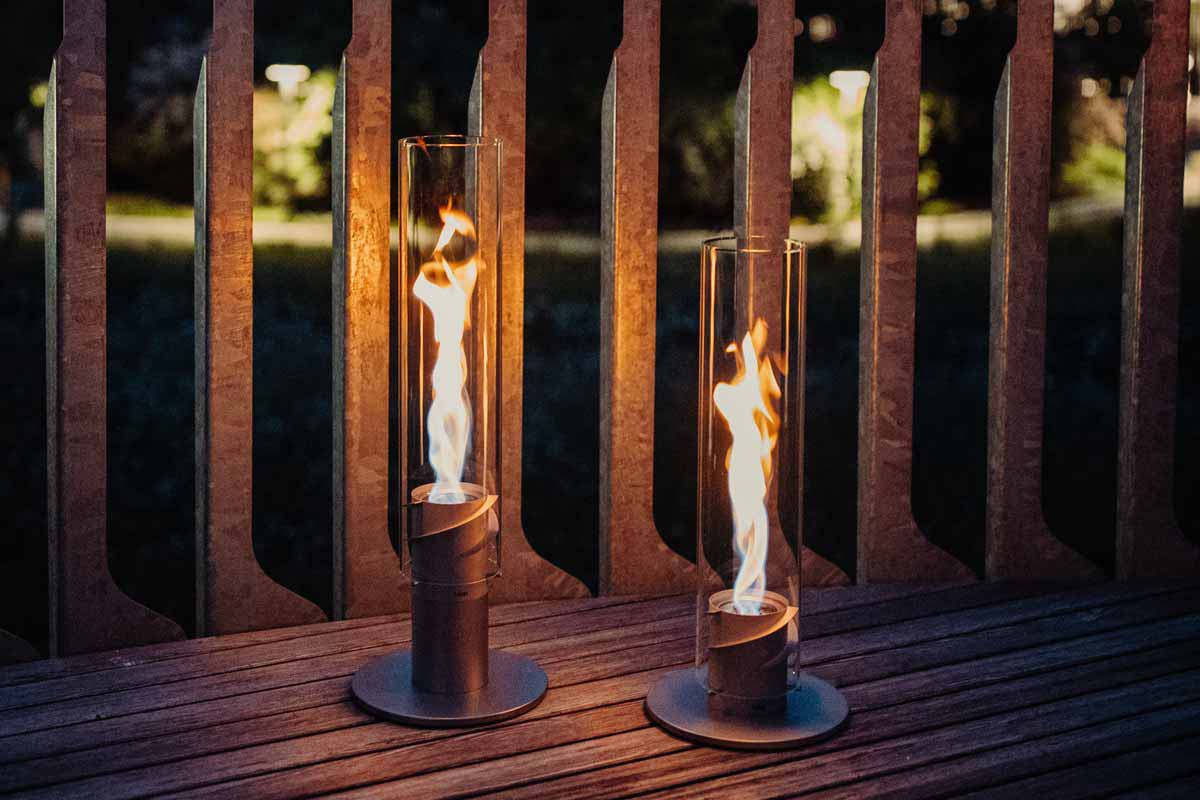 SPIN 1200 Stand Elevation silver This image shows two candles on a wooden table, with the SPIN 90 Table Fire silver.