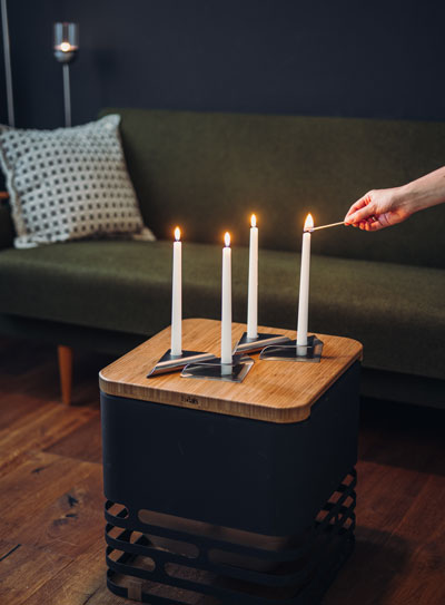 a person lighting candles on a small table.