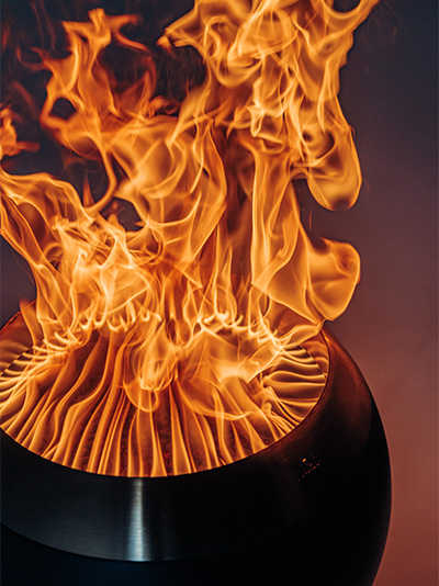 An inviting scene with a fire pit with flames burning inside, highlighted by the presence of the MOON 45