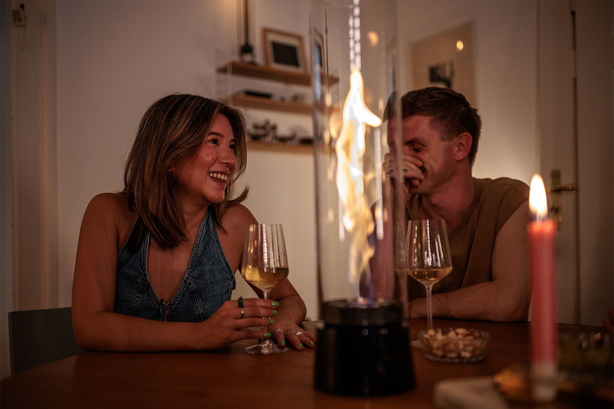 Le Spin Air 1200 Tablefire Emaille ajoute un charme cosy à la pièce où une femme se détend sur un canapé.