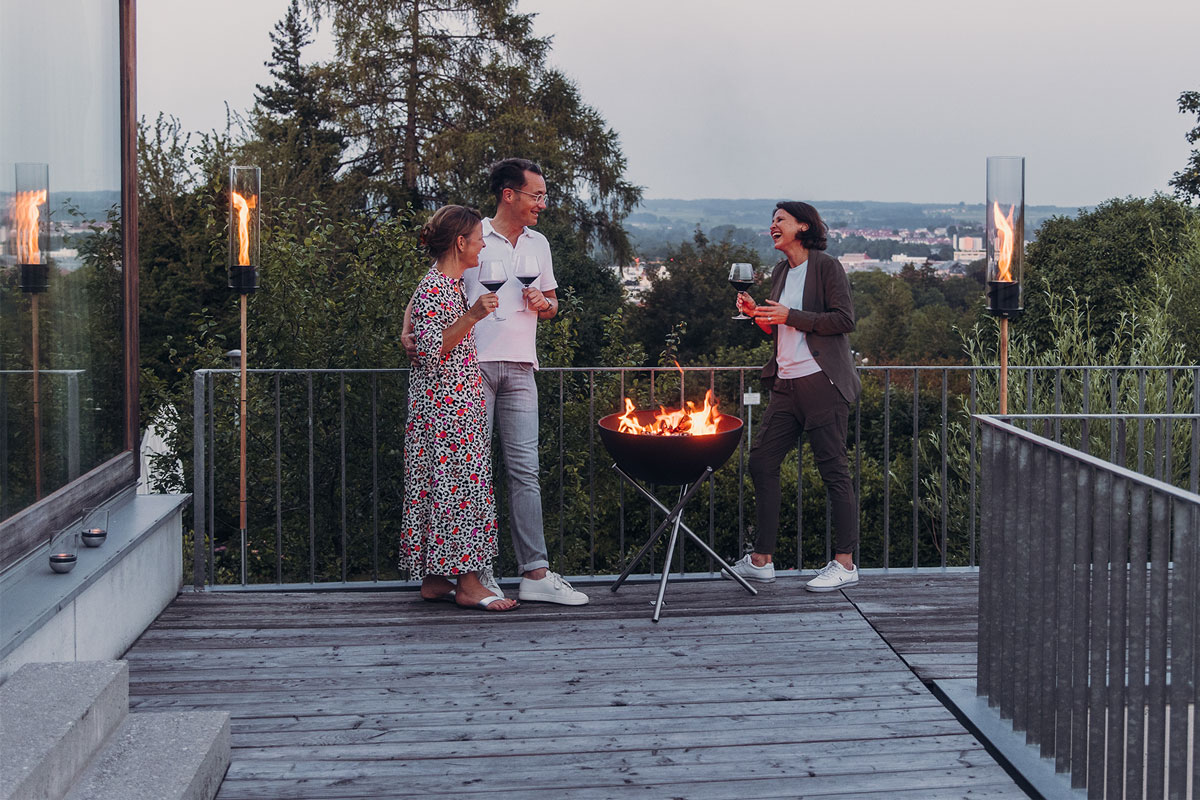 Dieses Bild zeigt einen Mann und eine Frau, die auf einem Deck mit Feuer stehen, mit dem BOWL 57 Fire Set flex.