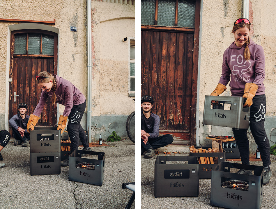 This image shows a woman is putting a pizza box in front of a house, with the BEER BOX Fire Basket.