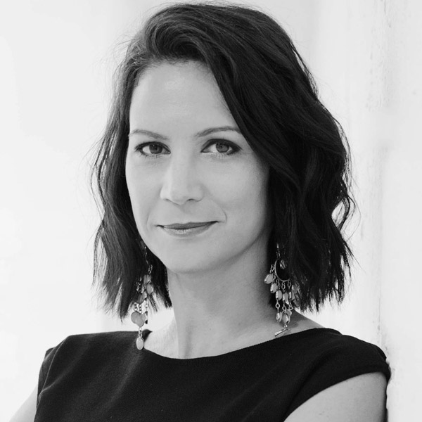 Une femme aux cheveux courts et portant un haut noir.