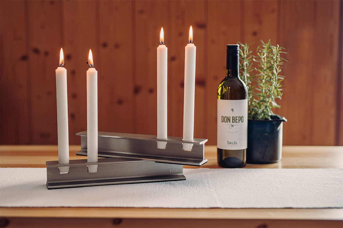 Cette image montre une bouteille de vin et une bougie sur une table, avec le bougeoir HENRY METAL II en argent.