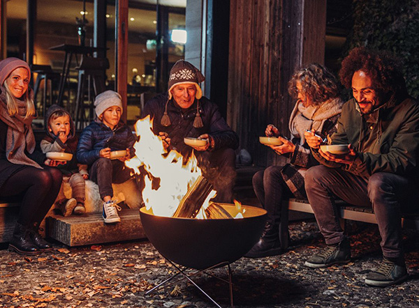 Winterzeit ist Feuerzeit Eine Familie sitzt um BOWL herum
