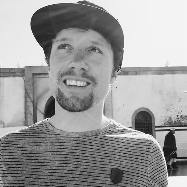 Un homme avec un chapeau et une SHIRT à rayures.