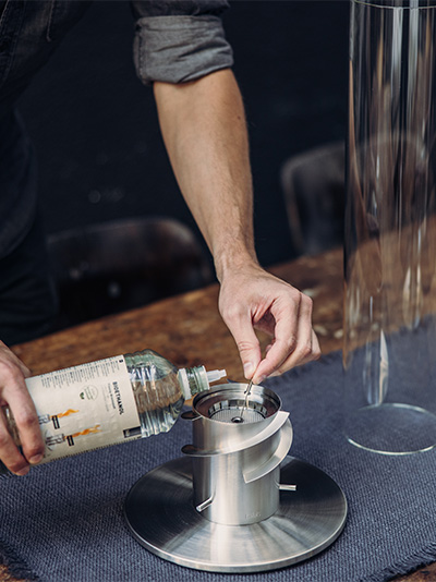 The Spin 1500 Pedestal Fireplace is shown as a man pouring a drink, creating a stylish and accessible visual.