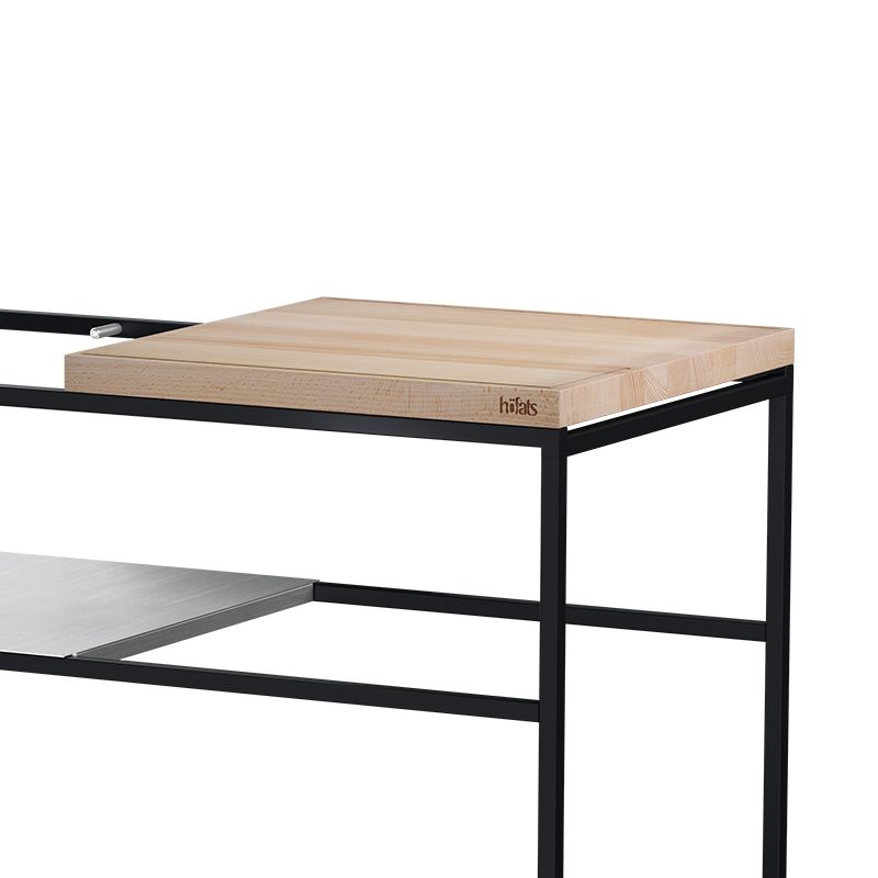 La photo présente une table en bois avec un cadre en métal et un plateau en bois, avec le plan de travail FIRE KITCHEN.
