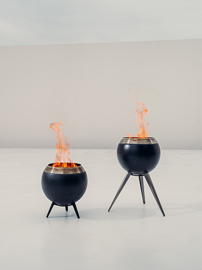 Two black fire pits with flames on them the Moon 45 complements the moment with its thoughtful design.