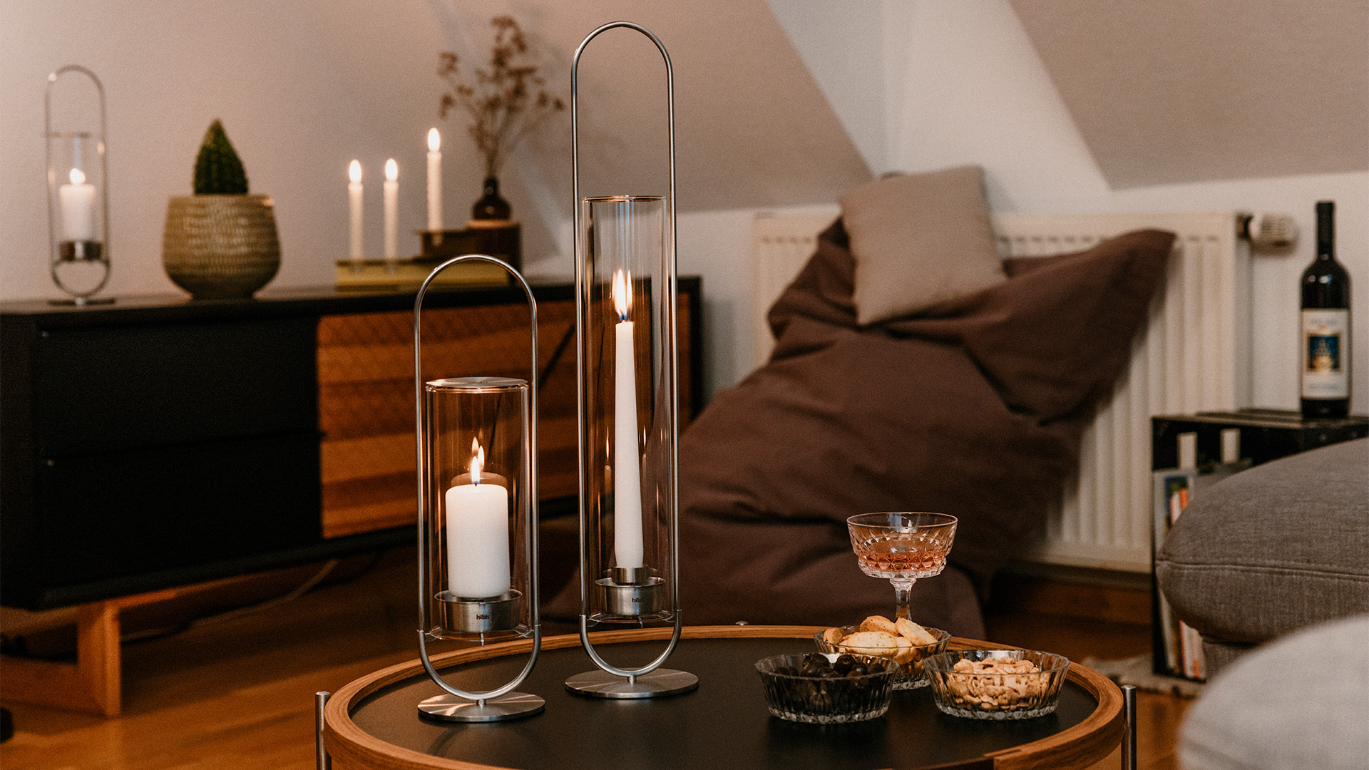 Une image montrant une table avec une bougie et un verre dessus, avec le OVAL CANDLE 55 Glass Cylinder.