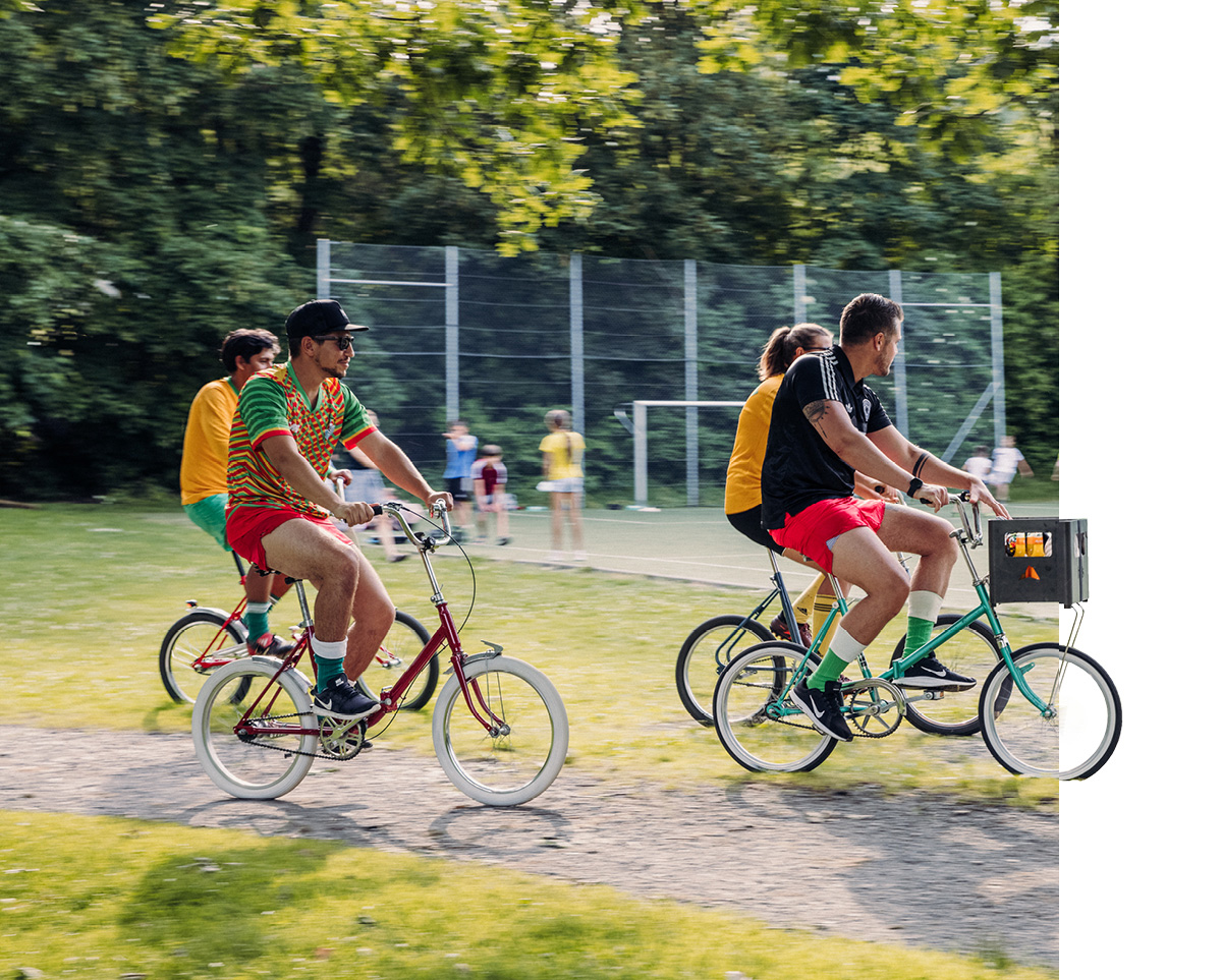 Ein Bild zeigt zwei Personen, die auf einem Weg Fahrrad fahren.