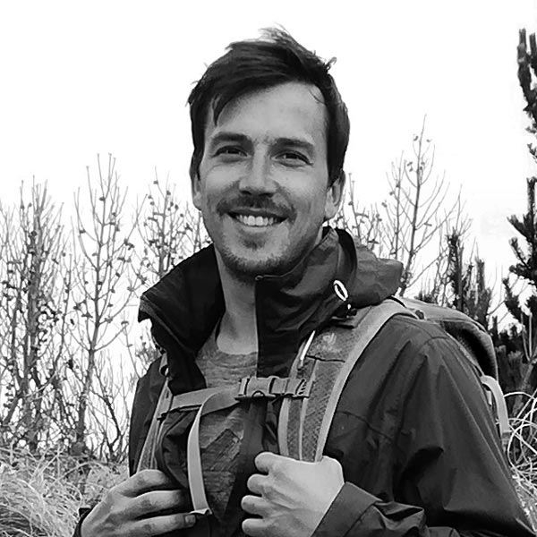 Un homme dans un champ avec un sac à dos.