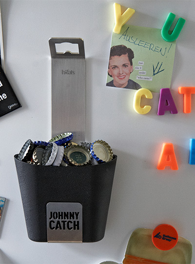 Illustré est un réfrigérateur blanc avec des aimants et un verre JOHNNY CATCH.