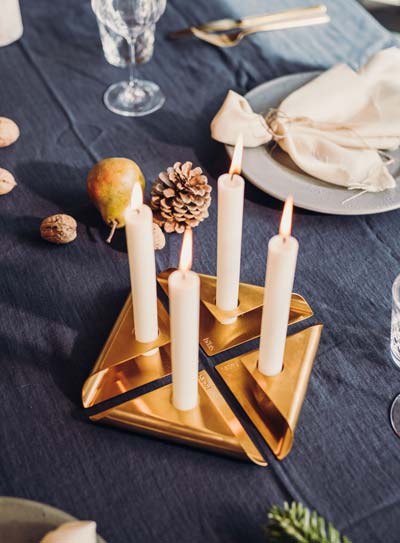Ici est représentée une table avec des bougies et des assiettes dessus, avec la SQUARE CANDLE .