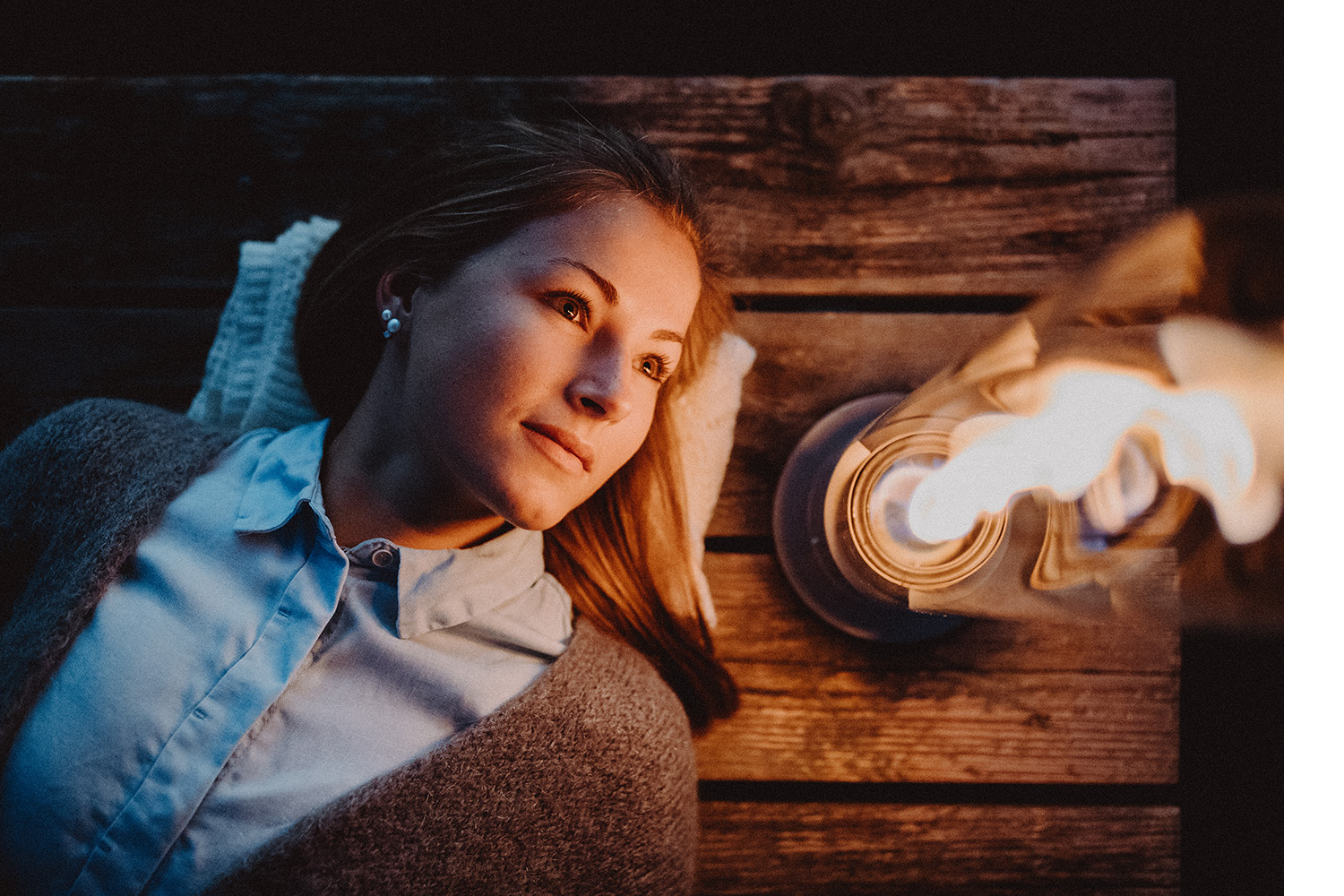 Eine Frau liegt auf dem Rücken und schaut auf das Feuer eines SPIN Tischfeuer.
