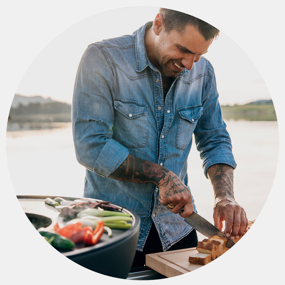 a man cutting a piece of pizza on a table.