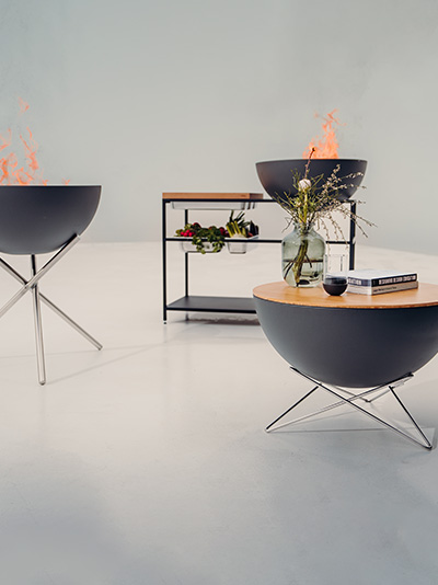 The Bowl accessoirs integrate seamlessly into the setting, with a white room with two BOWL Firebowls and a fire.