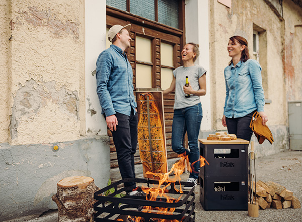 Flammlachs-Rezepte Ein Paar steht neben einer Feuerstelle.