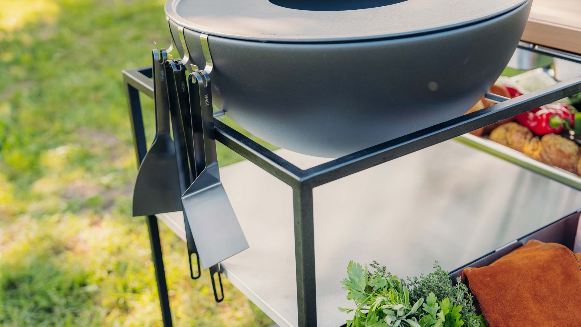 A grill with a pot of vegetables on it, with the 00858 Spatula black adding a functional and elegant touch to the scene.