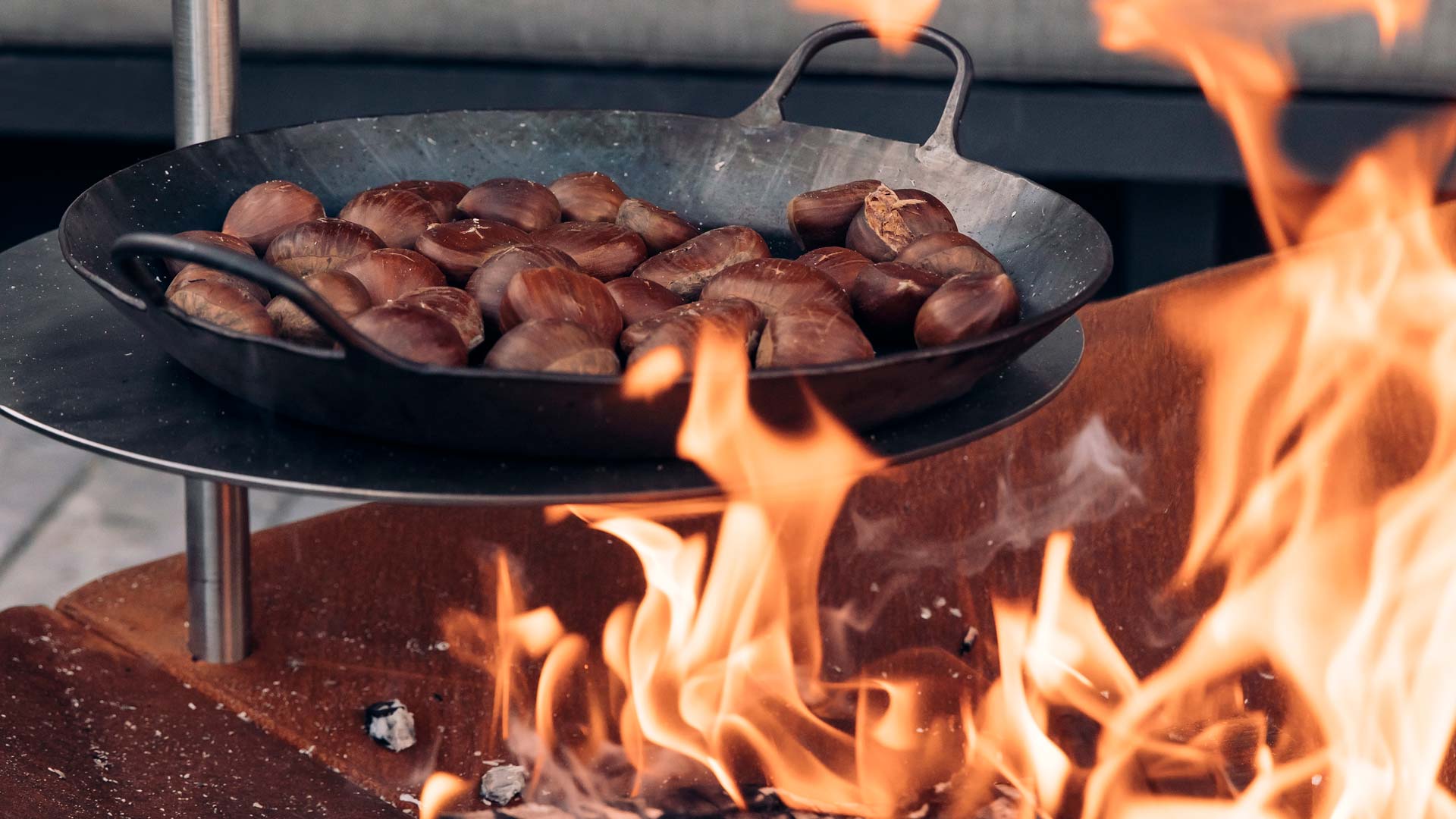 A view of a pan of hot hot dogs on a fire, with the TRIPLE Table.