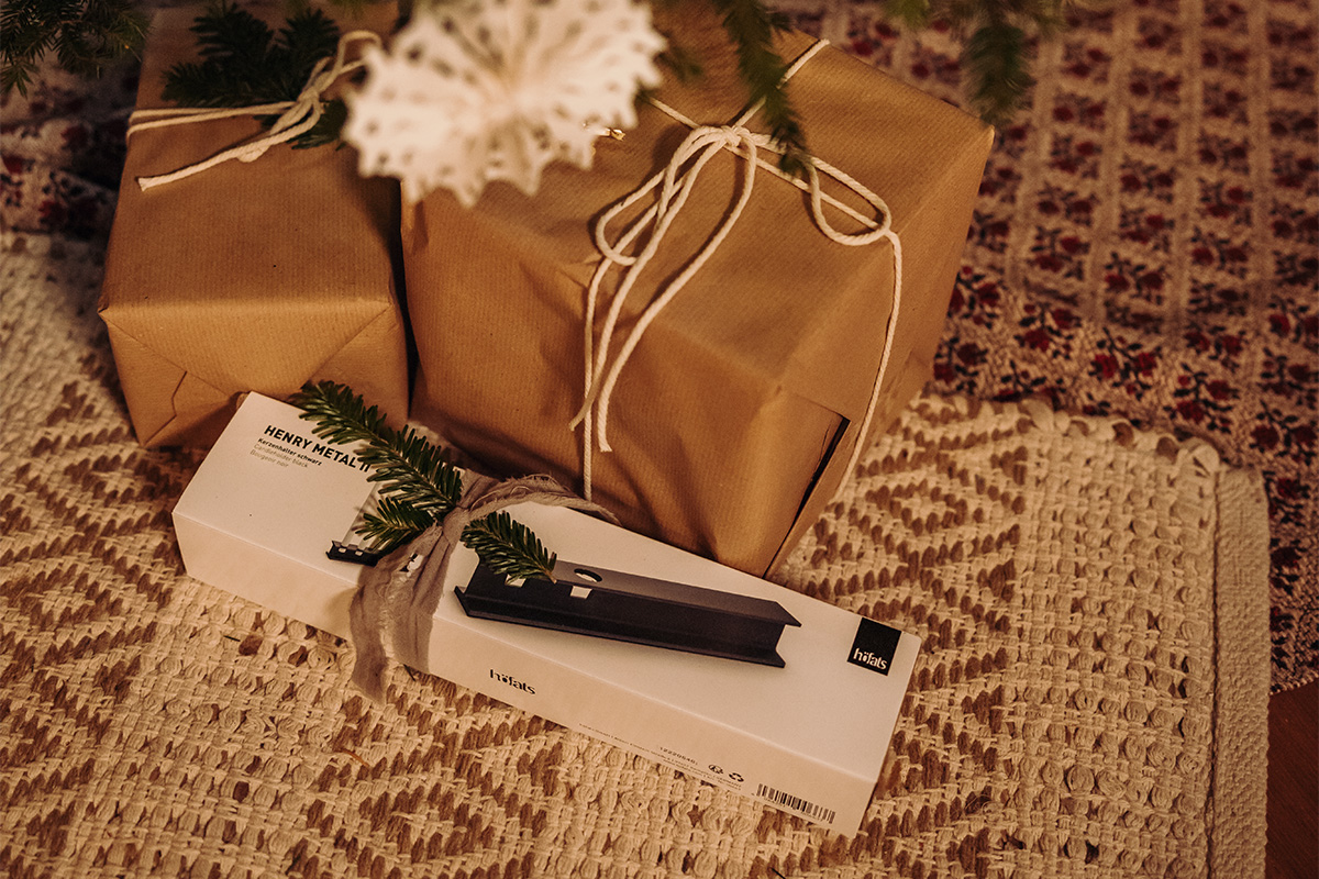 HENRY METAL II Candleholder black The 00663 Henry Metal II black is shown next to wrapped christmas presents, creating a stylish and accessible visual.