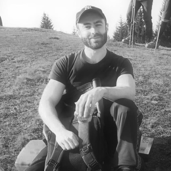 Un homme assis par terre avec les pieds croisés.