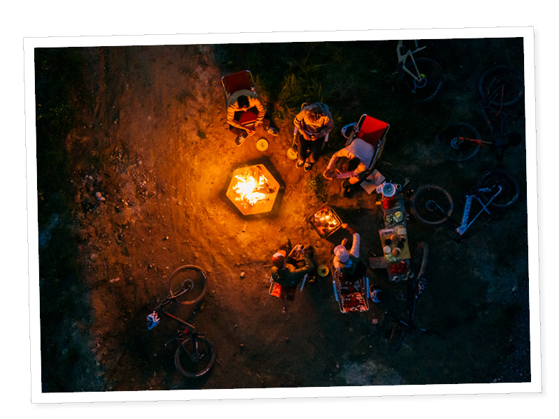 Un groupe de personnes assises autour d'un feu.