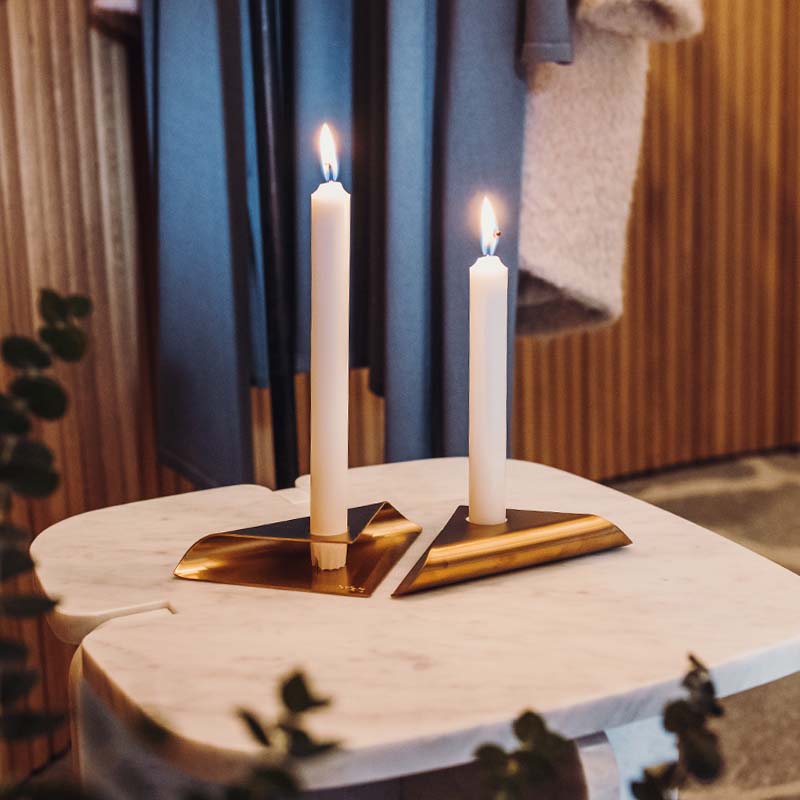 A view of a candle on a table with a towel and towel, with the SQUARE CANDLE Candleholder black.