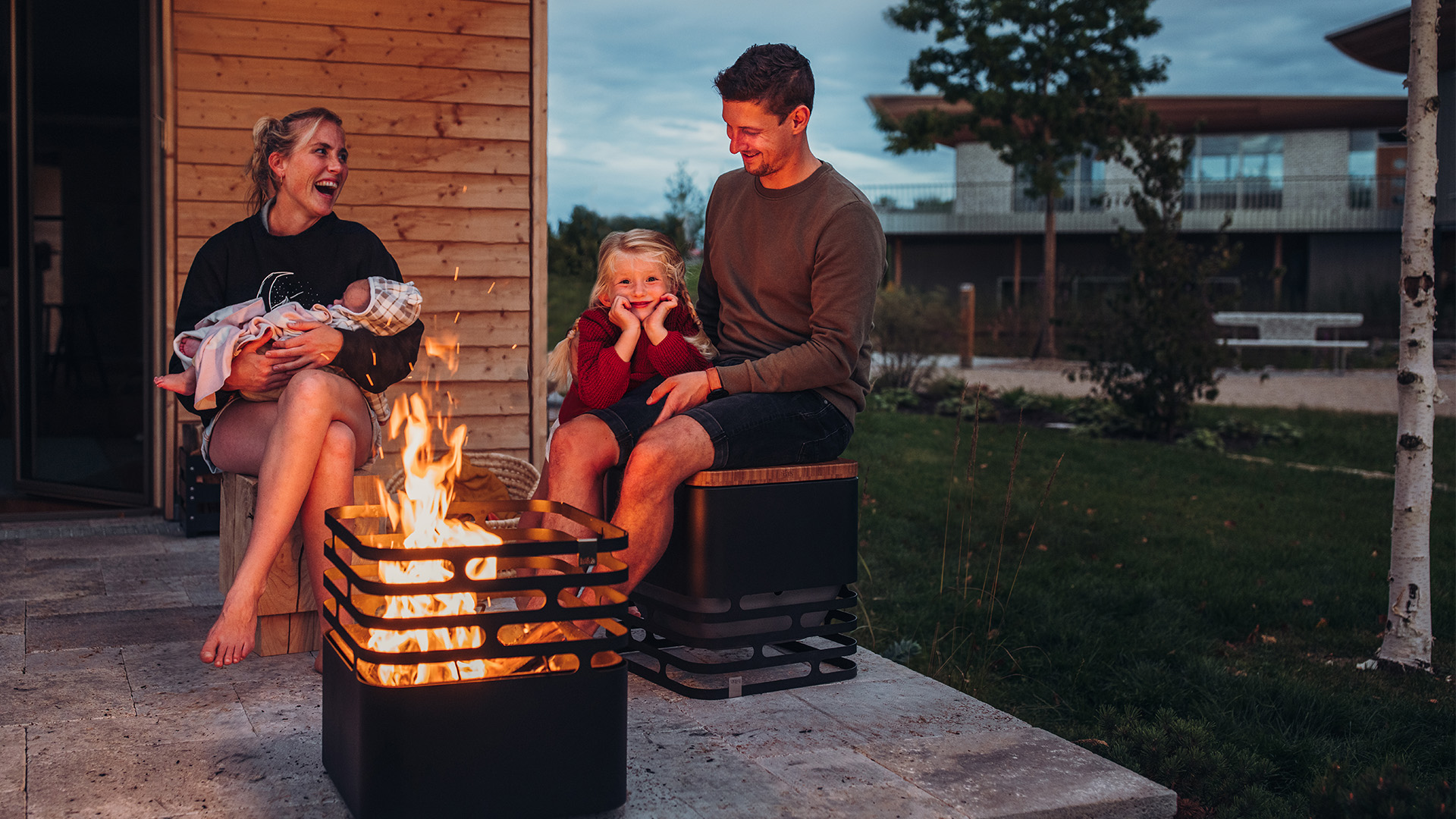 Le CUBE Flip est représenté par un homme et une femme assis sur un banc près d'un feu, créant une image élégante et accessible.