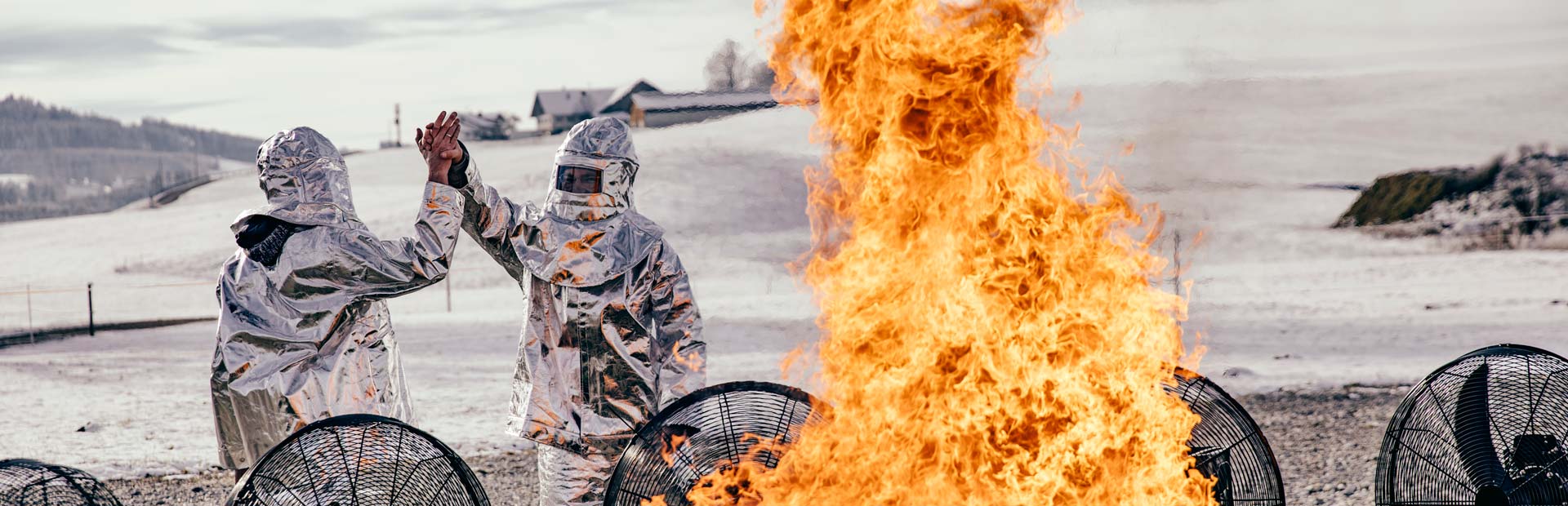 Deux personnes en armure debout autour d'un feu.